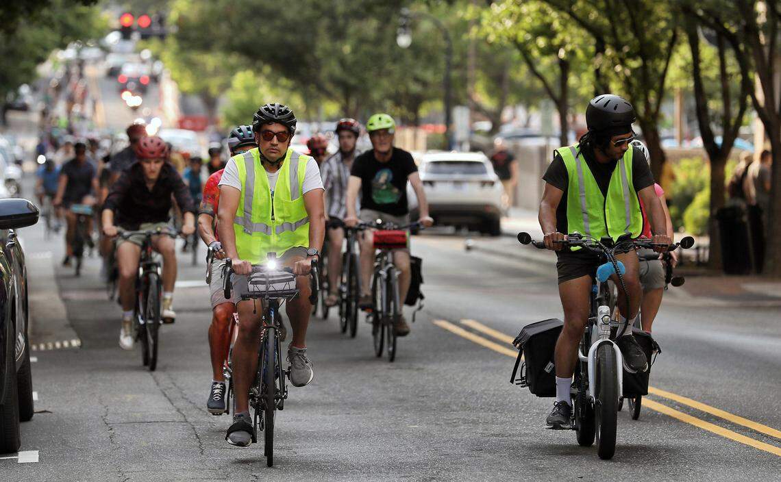 People ride bikes through downtown Durham, N.C. during the Ride of Silence on Wednesday, May 17, 2023. The event remembers those who were killed or injured while biking.