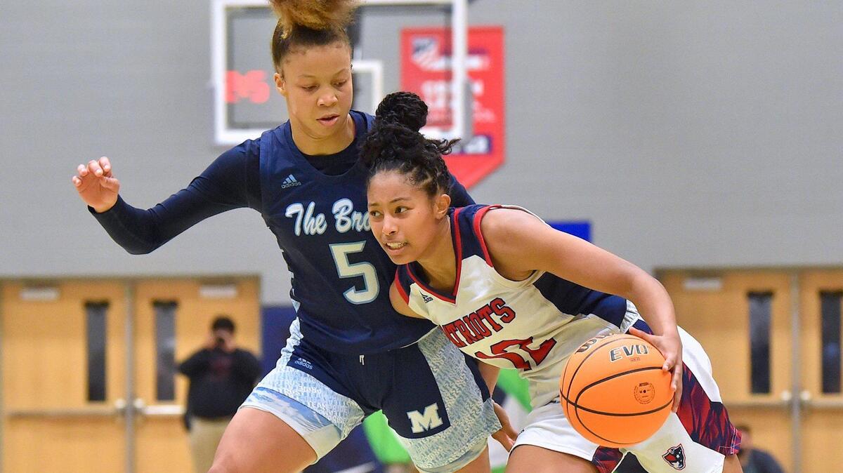 Apex Friendship’s Indya Nivar (12) drives towards the lane against Millbrook’s Reychel Douglas (5) in the second half. The Millbrook Wildcats and the Apex Friendship Patriots met in the NCHSAA 4A Girls East Regional Finals in Cary, N.C. on March 5, 2022.