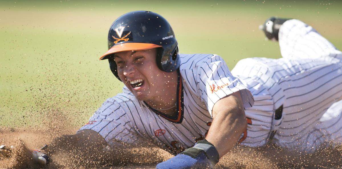Virginia's Jake McCarthy (31) dives safely back to first base after being caught in a pickle by N.C. State pitcher Reid Johnson in the third inning during the ACC Championship on Thursday, May 24, 2018 at Durham Bulls Athletic Park in Durham, N.C.