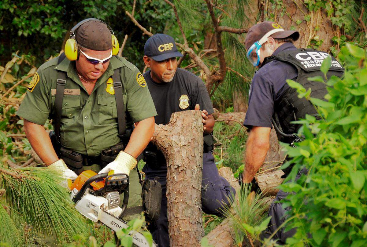 Customs and Border Protection and Border Patrol officers work to clear the entry way for an elderly couple desperate to return to their home in Wilmington, NC after Hurricane Florence.