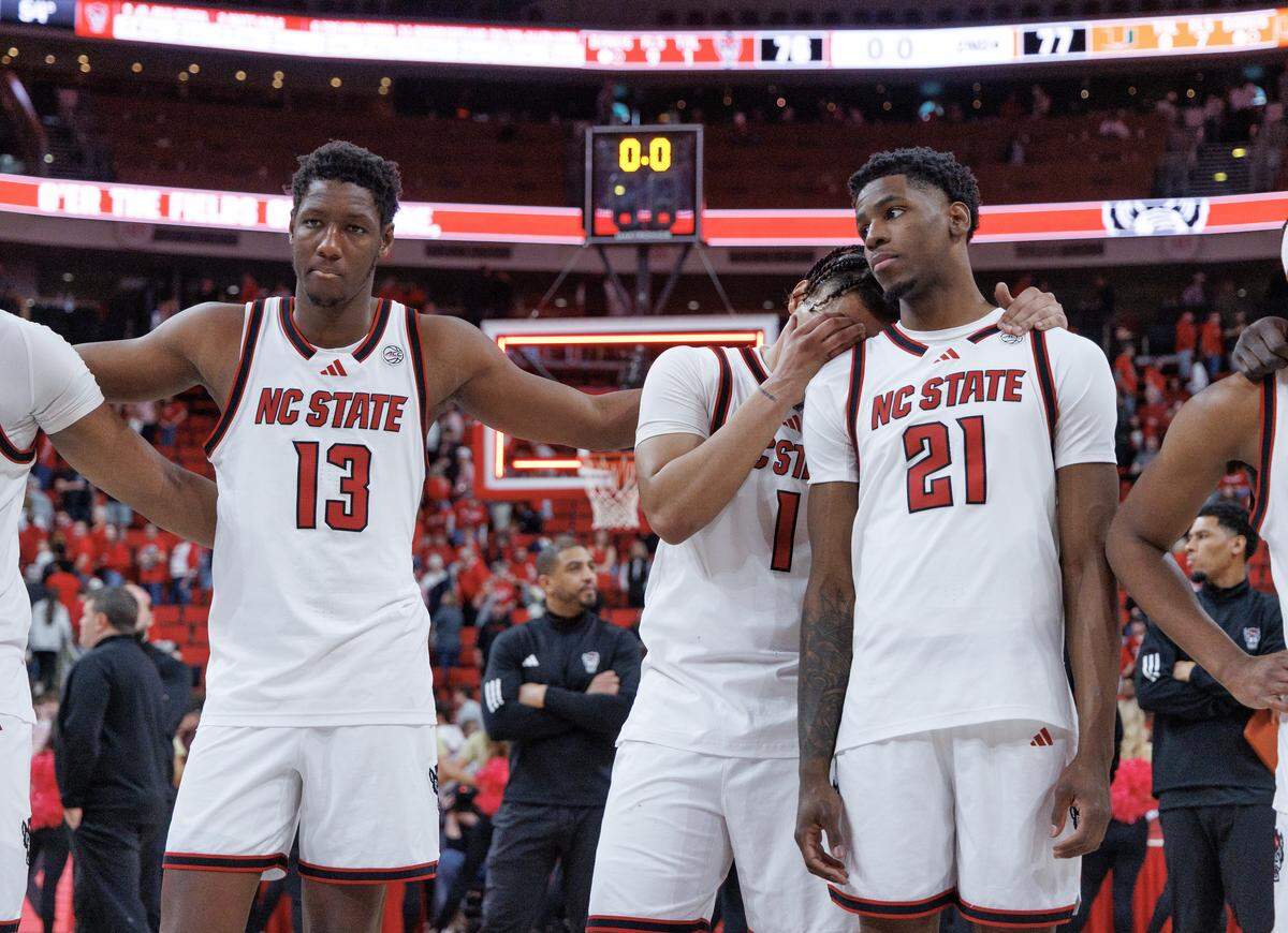 N.C. State’s Musa Sagnia, Darrion Williams and Terrance Arceneaux listen to the alma mater following the Wolfpack’s 77-76 loss to Miami on Saturday, Feb. 14, 2026, at Lenovo Center in Raleigh, N.C. 