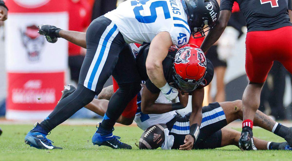 N.C. State quarterback CJ Bailey (16) fumbles the ball while being tackled by Duke linebacker Ozzie Nicholas (45) during the first half of N.C. State’s game against Duke at Carter-Finley Stadium in Raleigh, N.C., Sat. Nov. 9, 2024.