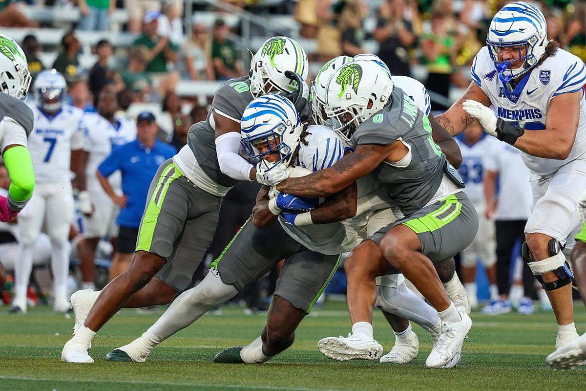 Sutton Smith (5) of the Memphis Tigers is tackled by Devin Hightower (0) and Jalen Cheek (10) of the UAB Blazers during the second half at Protective Stadium on October 18, 2025 in Birmingham, Alabama.