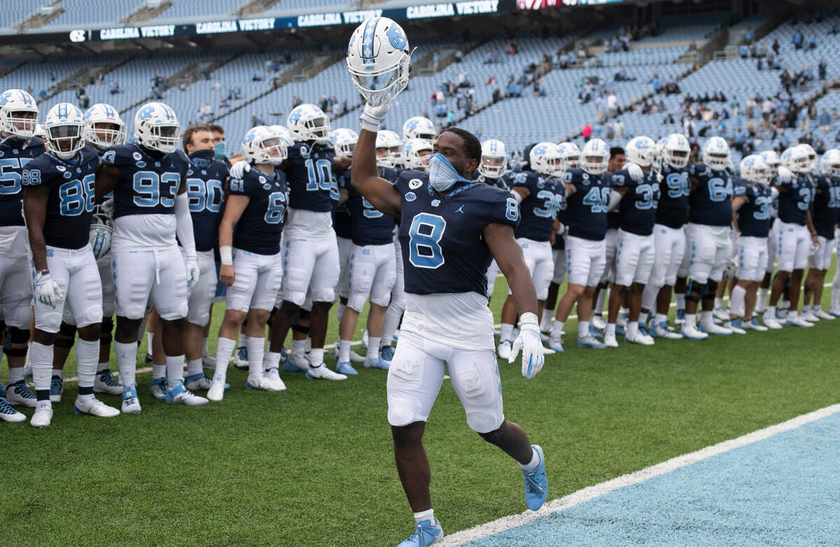 North Carolina’s Michael Carter (8) leads the celebration following the Tar Heels’ 56-49 victory over Virginia Tech on Saturday, October 10, 2020 at Kenan Stadium in Chapel Hill, N.C. Carter rushed for 214 yards and two touchdowns.