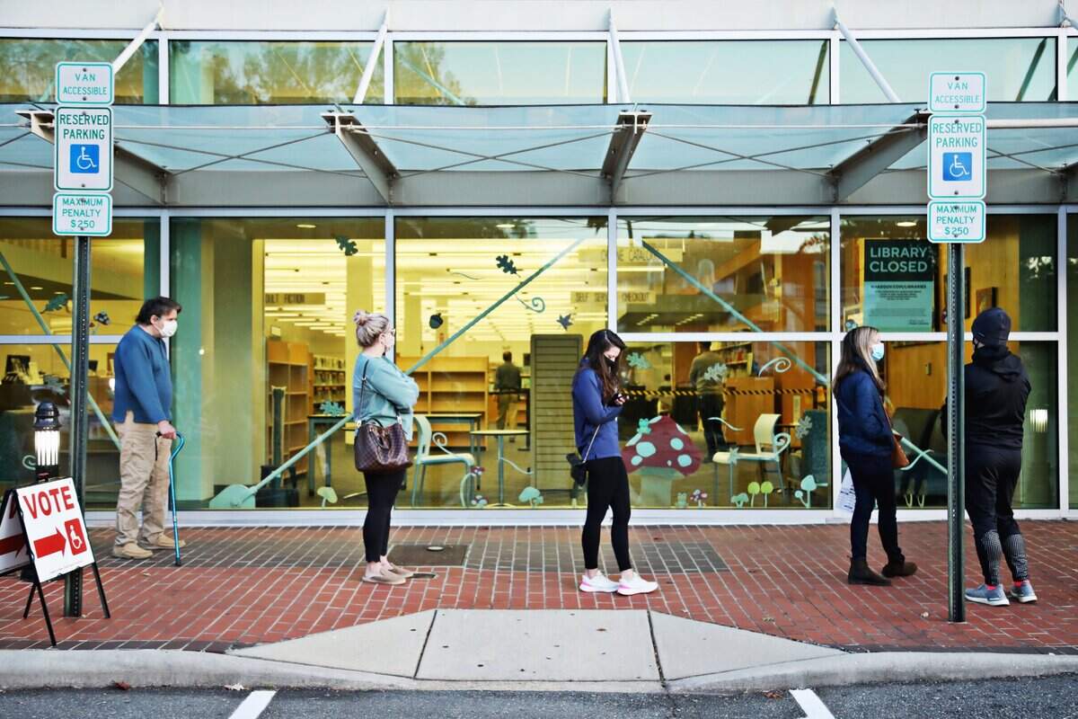 A steady line of voters wait outside of Cameron Village Library early Tuesday morning, Nov. 3, 2020, for their turn to go inside the library and vote.