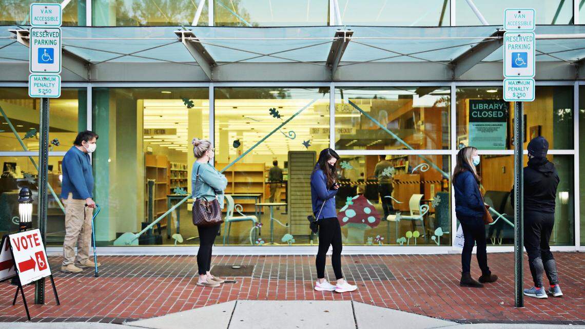 A steady line of voters wait outside of Cameron Village Library early Tuesday morning, Nov. 3, 2020, for their turn to go inside the library and vote.