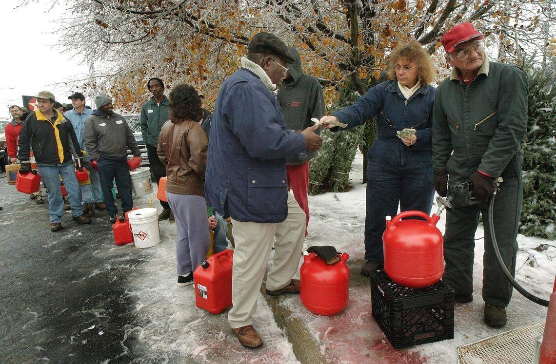 Ben Robinson, of Durham, (at left) pays Bonnie Bowen for kerosene as her husband Tom Bowen watches the gauge at the Texaco Food Mart on Hillsborough Road in Durham. It was a popular spot as folks lined up to purchase fuel after Thursday's ice storm. The Bowen's had been selling Christmas trees but started helping the harried convenience store owner when the crowds overwhelmed the store. The Bowen's had pumped the tank dry once and it holds 350 gallons. 