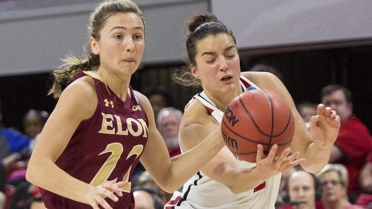North Carolina State's Aislinn Konig, right, knocks the ball away from Elon's Lexi Mercer (22) during the first half of a first-round game in the NCAA women's college basketball tournament in Raleigh, N.C., Friday, March 16, 2018.