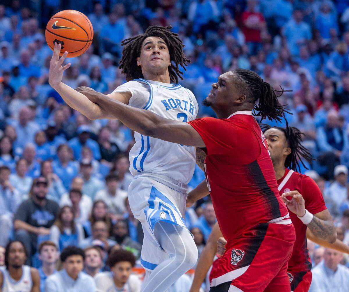 North Carolina’s Elliot Cadeau (2) drives to the basket against N.C. State’s D.J. Burns Jr. (30) in the second half on Saturday, March 2, 2023 at the Smith Center in Chapel Hill, N.C. Cadeau scored 15 points in the Tar Heels’ 79-70 victory.