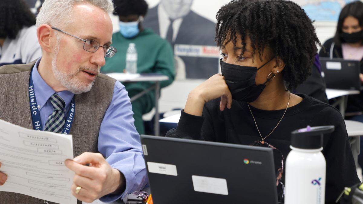 Junior Alysia Davis talks with IB History teacher Alex Christman at Hillside High School in Durham, N.C., Thursday, April 28, 2022.