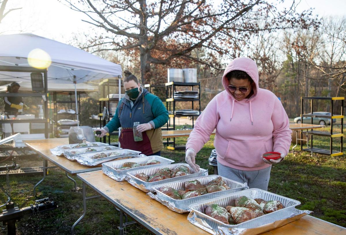 Molly McCambridge, left, and Katina Parker season turkey meat together on the second day of the five-day no-contact cookout known as Feed Durham that began as a response to the increase of food insecurity at the start of coronavirus pandemic, bringing dozens of volunteers to ParkerÕs front yard every six to eight weeks to cook well-seasoned and nutrient-dense meals for people in need, on Wednesday, Mar. 3, 2021, in Durham, N.C.