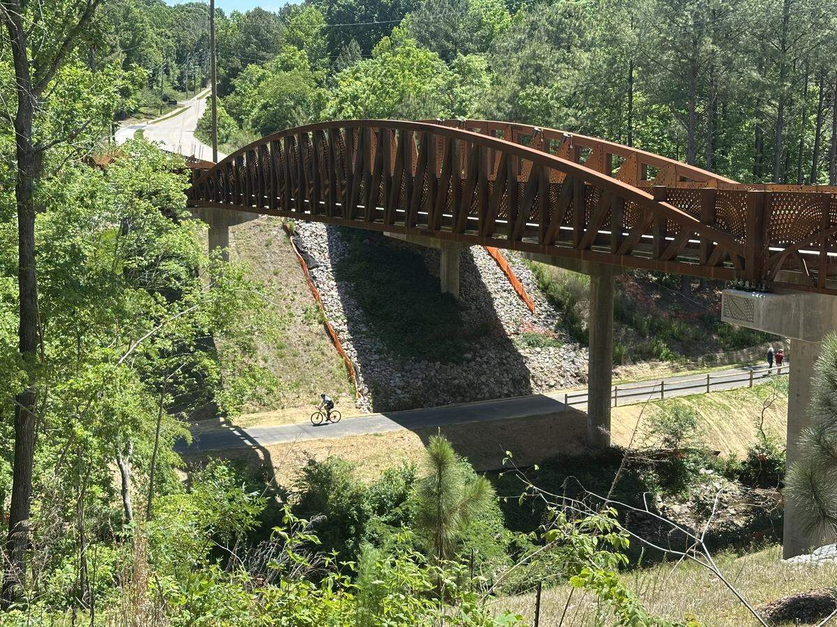 The new steel pedestrian bridge alongside Northwest Cary Parkway crosses 50 feet above Black Creek and the greenway trail that runs beside it.