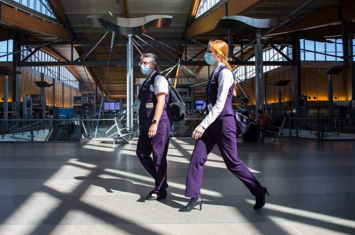 Flight attendants walk through RDU International Airport in Morrisville, N.C. on Friday, July 9, 2021.
