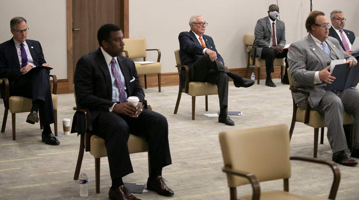 UNC Board of Governors member Leo Daughtry, center, and fellow governors practice social distancing during their meeting at the Friday Center on Friday, June 19, 2020 in Chapel Hill, N.C.