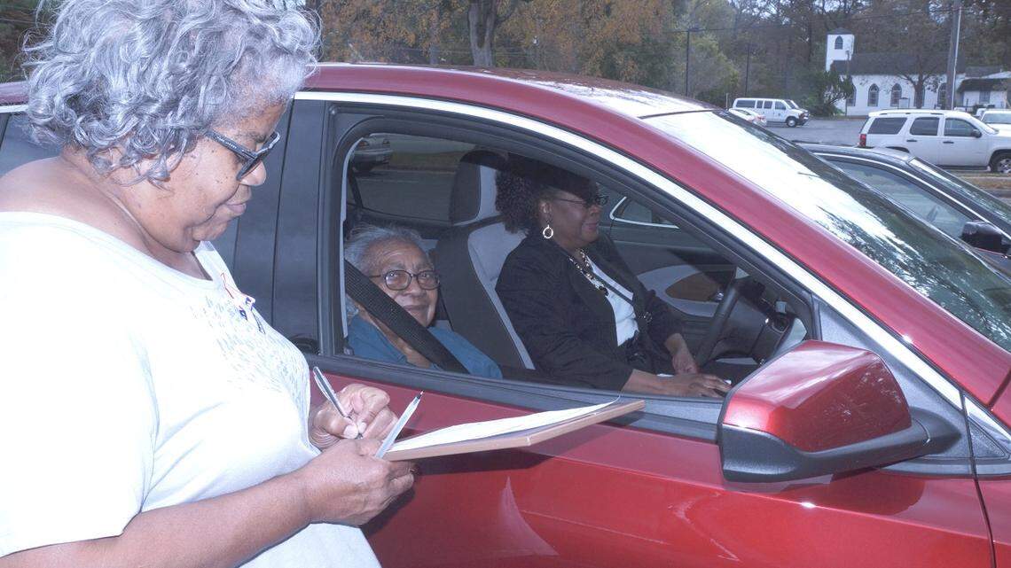 Margaret Myrick-Station assists 87-year-old Hattie Staton with curbside voting at the Edgecombe County Administration Building in Tarboro in November 2018.