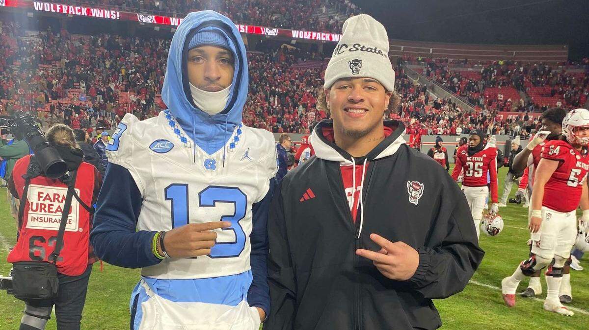 UNC wide receiver Tylee Craft, left, and N.C. State defensive tackle DJ Jackson pose for a photo after the Wolfpack beat the Tar Heels, 39-20, on Nov. 25, 2023, at Carter-Finley Stadium in Raleigh.