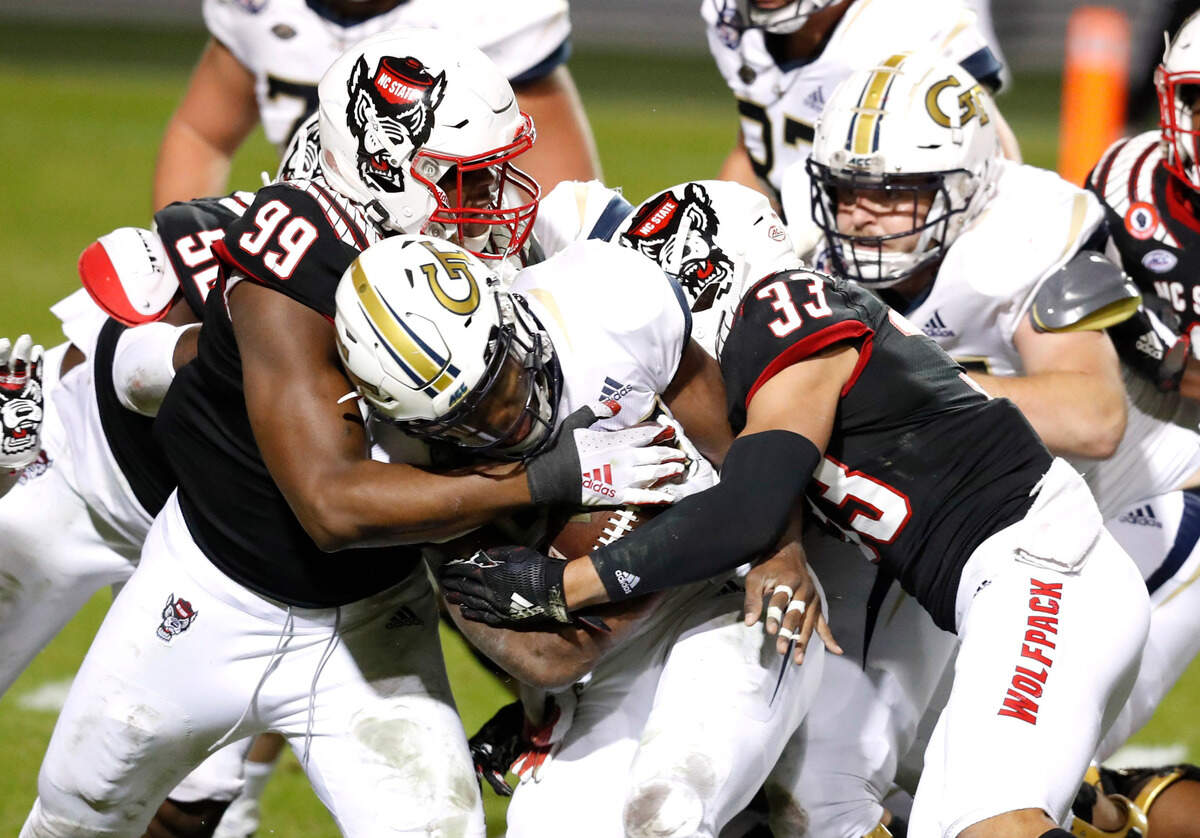 N.C. State’s Daniel Joseph (99) and Isaac Duffy (33) tackle Georgia Tech running back Jordan Mason (27) during the second half of N.C. State’s 23-13 victory over Georgia Tech at Carter-Finley Stadium in Raleigh, N.C., Saturday, Dec. 5, 2020.