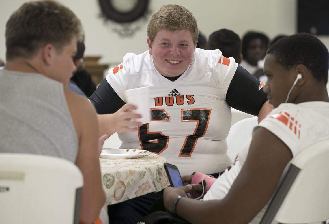 Wallace-Rose Hill’s Eric Hanchey (67) enjoys some social time with his teammates over a pre-game meal at Corinth Baptist Church on Friday, October 5, 2018 in Teachey, N.C. Most of the players were displaced during Hurricane Florence and were anxious to get back on the playing field after nearly a month since their last game.