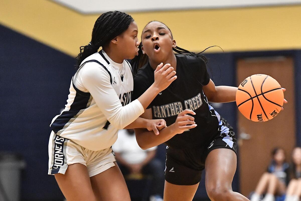 Panther Creek’s Taylor Barner (2) drives to the lane against Hillside’s McKenzy Green (1) during the first half. The Hillside Hornets and the Panther Creek Catamounts met in the NCHSAA 4A East Regional Finals in Sanford, N.C. on March 4, 2023.