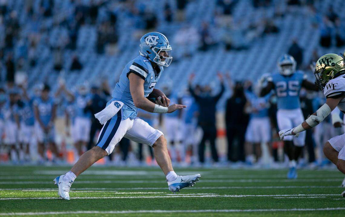 North Carolina quarterback Sam Howell (7) scores the game winning touchdown on a 20-yard carry ahead of Wake Forest’s Miles Fox (11) late in the fourth quarter to give the Tar Heels’ a 52-45 lead.