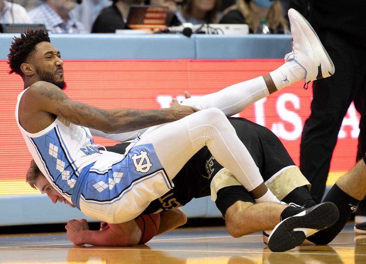 North Carolina’s Leaky Black (1) falls on Wake Forest’s Andrew Carr (11) as they chase a loose ball in the second half on Wednesday, January 4, 2023 at the Smith Center in Chapel Hill, N.C.