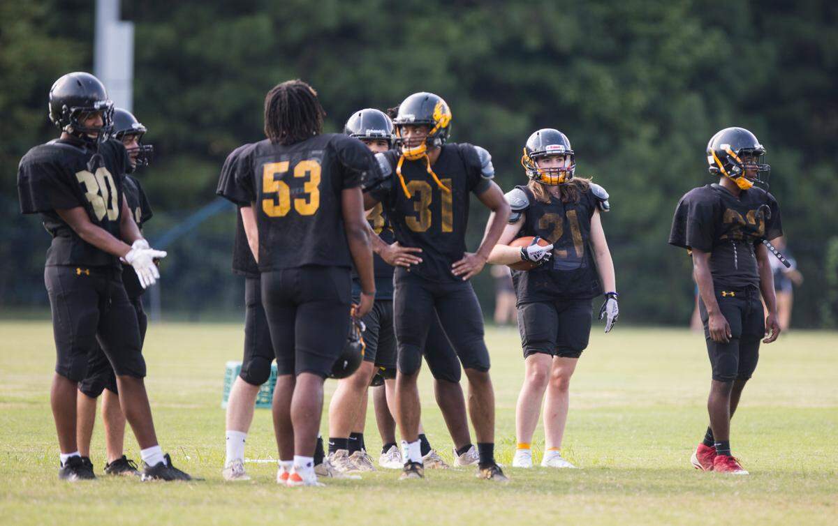 Chapel Hill High School varsity football player Brooklyn Harker, second from right, stands with her teammates during practice in Chapel Hill, N.C. on Tuesday, Sept. 14, 2021.