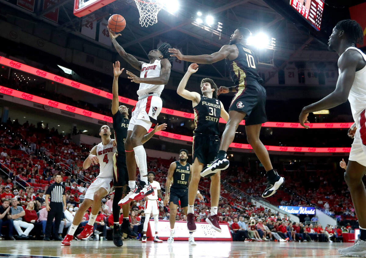 N.C. State’s Dereon Seabron (1) shoots as Florida State’s Caleb Mills (4), Wyatt Wilkes (31) and Malik Osborne (10) try to defend during Florida State’s 83-81 victory over N.C. State at PNC Arena in Raleigh, N.C., Saturday, Jan. 1, 2022.