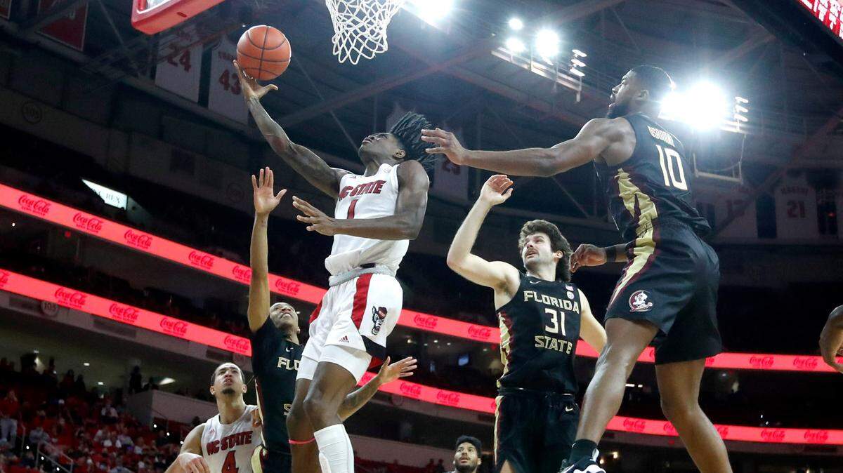 N.C. State’s Dereon Seabron (1) shoots as Florida State’s Caleb Mills (4), Wyatt Wilkes (31) and Malik Osborne (10) try to defend during Florida State’s 83-81 victory over N.C. State at PNC Arena in Raleigh, N.C., Saturday, Jan. 1, 2022.