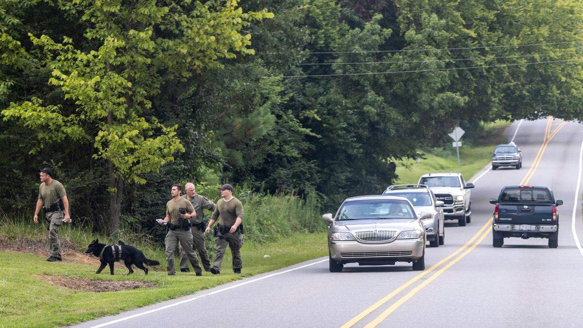 Emergency personnel scour a search area Friday, July 29, 2022 in Fuquay-Varina, NC after a twin-engine turboprop aircraft made an emergency landing at RDU International Airport and skidded off the runway. A person exited the plane prior to the emergency landing and was found dead in a Fuquay-Varina residential backyard.