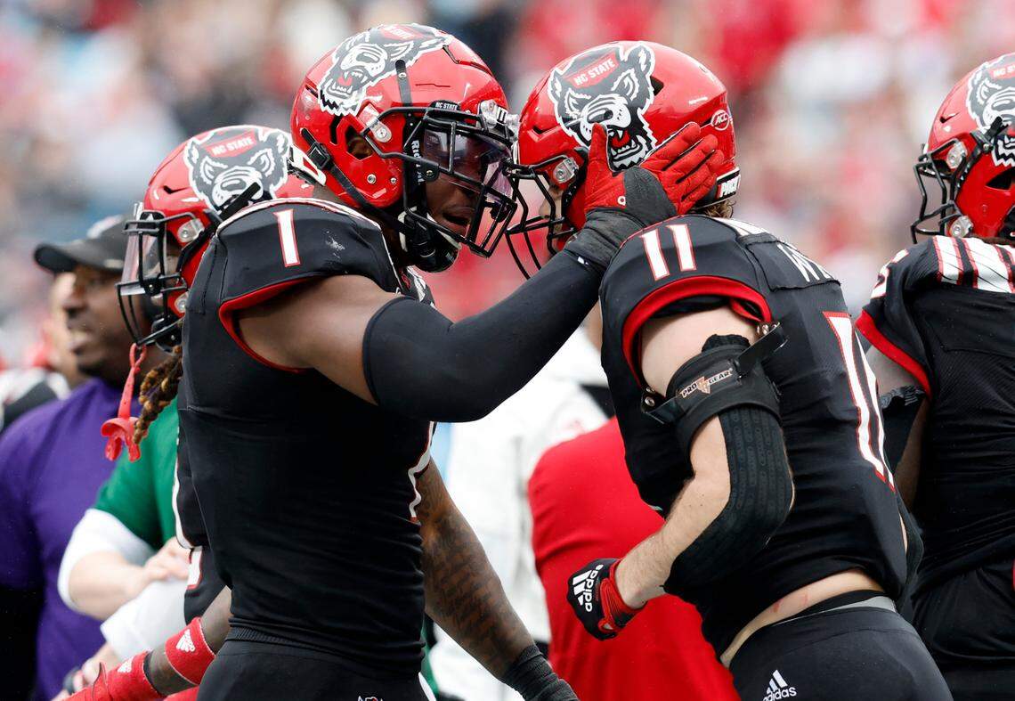 N.C. State’s Isaiah Moore (1) celebrates with Payton Wilson (11) after Wilson forced Maryland quarterback Taulia Tagovailoa (3) out of bounds during the first half of N.C. State’s game against Maryland in the Duke’s Mayo Bowl at Bank of America Stadium in Charlotte, N.C., Friday, Dec. 30, 2022.