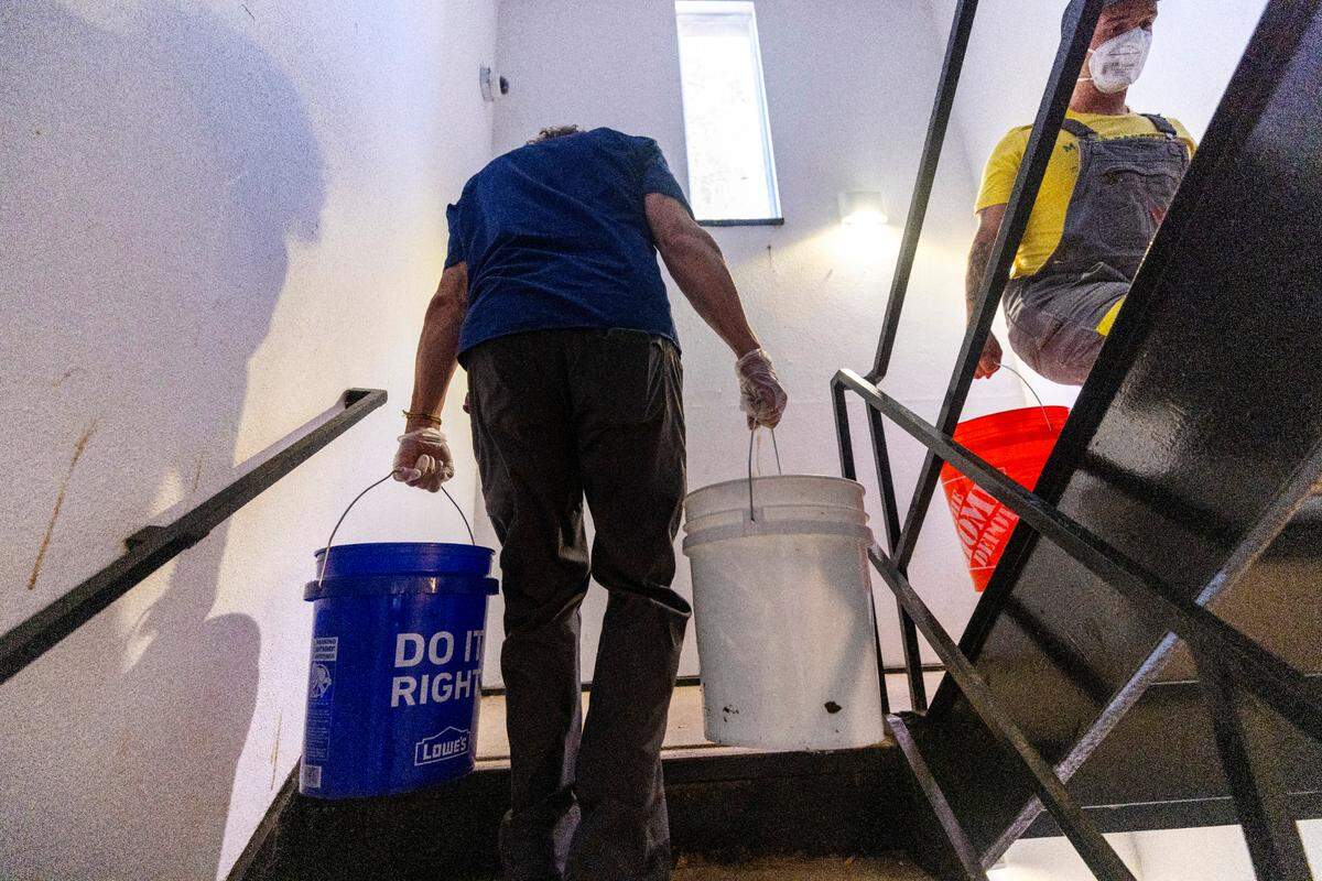 Volunteers organized by grassroots group BeLoved Asheville haul gray water to help residents in low-income independent living facilities, with no running water, flush their toilets on Wednesday, Oct. 9, 2024. About half of Asheville’s water customers were still without running water this week because the remnants of Hurricane Helene ripped apart the city’s distribution system.
