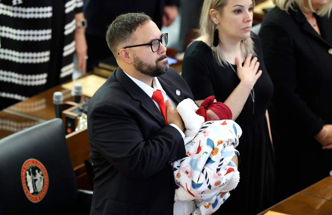 Rep. Jarrod Lowery holds his 21-day-old daughter Madysn as the Pledge of Allegiance is recited during the opening session of the N.C. House of Representatives Wednesday, Jan. 11, 2023.