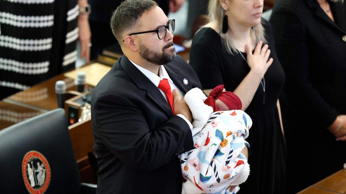 Rep. Jarrod Lowery holds his 21-day-old daughter Madysn as the Pledge of Allegiance is recited during the opening session of the N.C. House of Representatives Wednesday, Jan. 11, 2023.