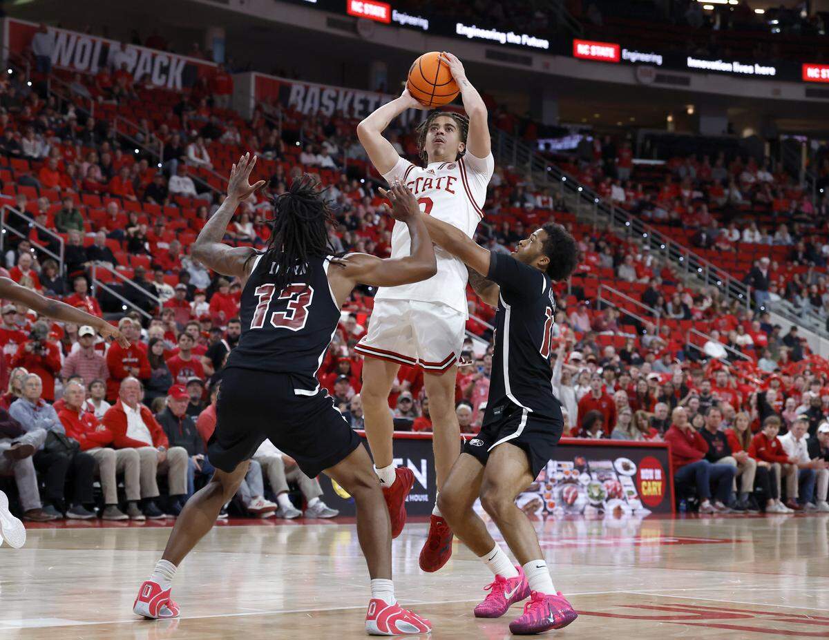 N.C. State’s Jordan Snell shoots over North Carolina Central’s Jonathan Dunn and Ryan Archey during the second half of the Wolfpack’s 114-66 win at Lenovo Center on Monday, Nov. 3, 2025, in Raleigh, N.C.