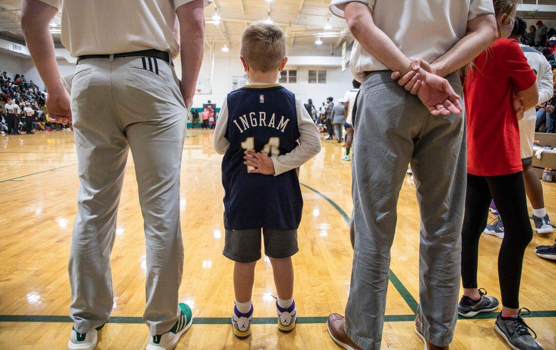 Truett “Tru” Tyndall, 5, the son of Kinston Vikings head coach Perry Tyndall, wears a Brandon Ingram jersey while standing with his dad and an assistant coach before Kinston’s game against Farmville Central at the inaugural Brandon Ingram MLK Showcase in Kinston, N.C. on Saturday, Jan. 15, 2022.