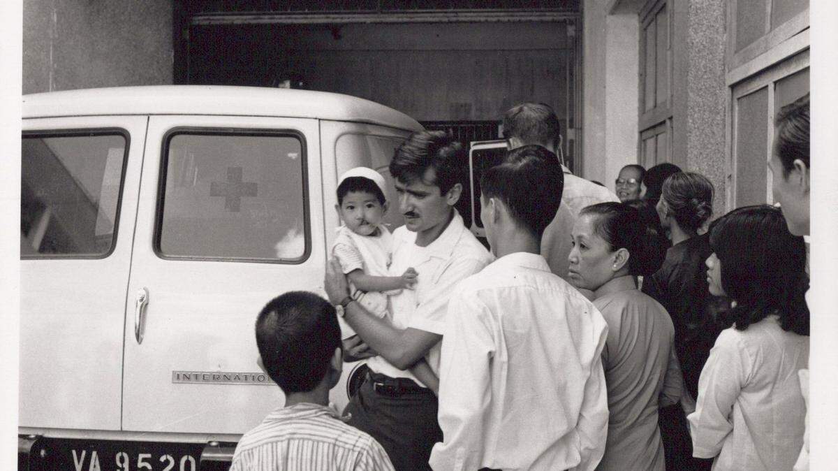 John Balaban, poet and retired English professor from NC State University, carries a Vietnamese child to an ambulance during his stint as a conscientious objector during the war in 1971-1972. Balaban’s experiences in the war are recounted in his collected works “Passing Through a Gate.”