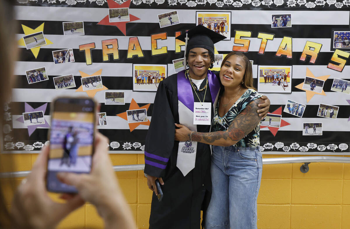 South Garner High School graduate Samauri Peoples poses with his former fifth grade teacher Semone Liquet as graduating seniors return to be celebrated at Powell Elementary in Raleigh  Wednesday.