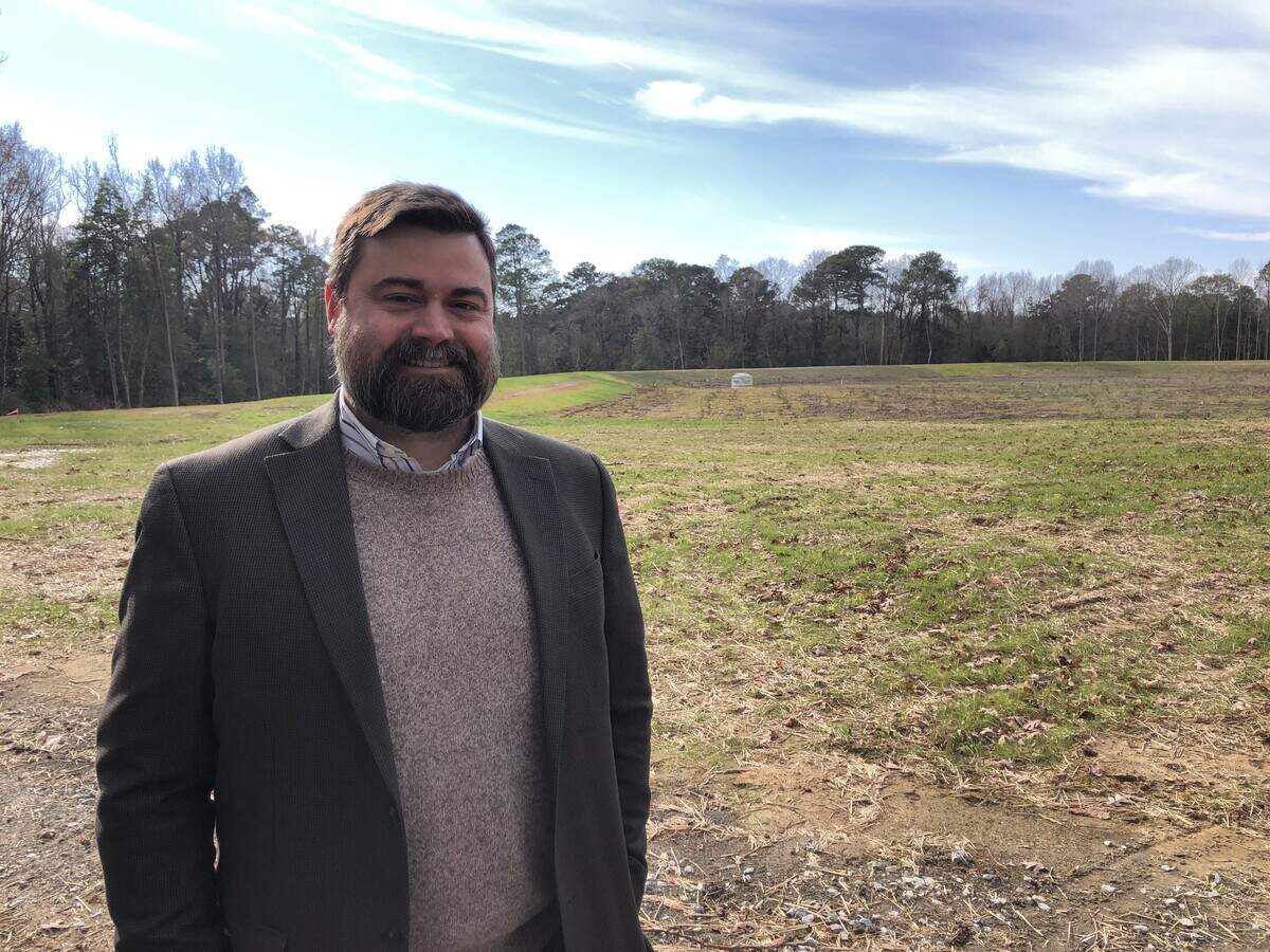 Goldsboro Mayor Charles Gaylor stands in front of a new 9-acre retention pond on the Wayne Community College campus designed to help reduce dangerous flooding that happens with extreme rainfall from storms.