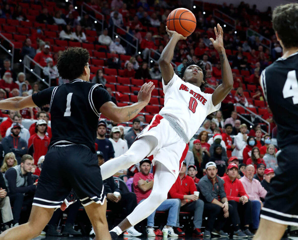 N.C. State’s Terquavion Smith (0) shoots after being fouled by Wright State’s Trey Calvin (1) during the second half of Wright State’s 84-70 victory over N.C. State at PNC Arena in Raleigh, N.C., Tuesday, December 21, 2021.