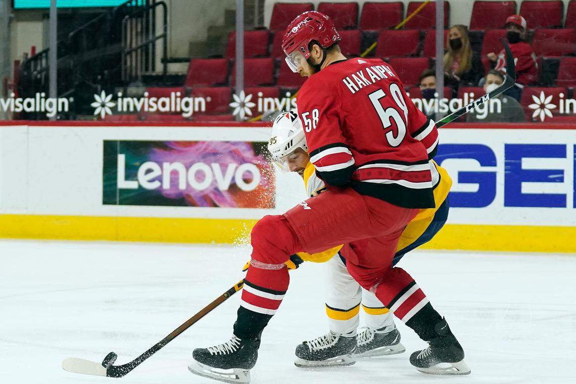 Carolina Hurricanes Jani Hakanpaa (58) and Nashville Predators center Matt Duchene (95) skate for the puck during the first period of an NHL hockey game in Raleigh, N.C., Saturday, April 17, 2021. (AP Photo/Gerry Broome)