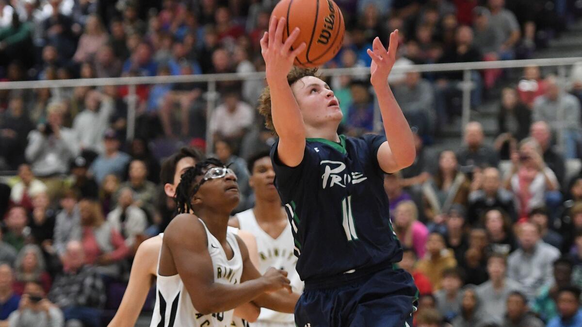 Carter Whitt (11) of Leesville Road drives with a layup against Sylvester White, left, of Trinity Academy. The Trinity Academy Tigers played the Leesville Road Pride in a high school basketball game that was part of the John Wall Holiday Invitational Tournament in Raleigh, N.C. on December 26, 2018.