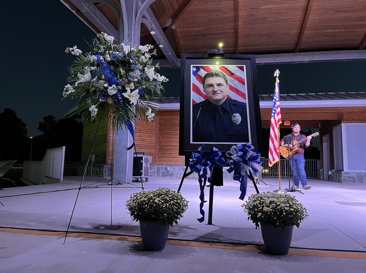A portrait of Knightdale police officer Ryan Hayworth is surrounded by flowers at a vigil for him at Knightdale Station Park on Wednesday, Oct. 20, 2021.