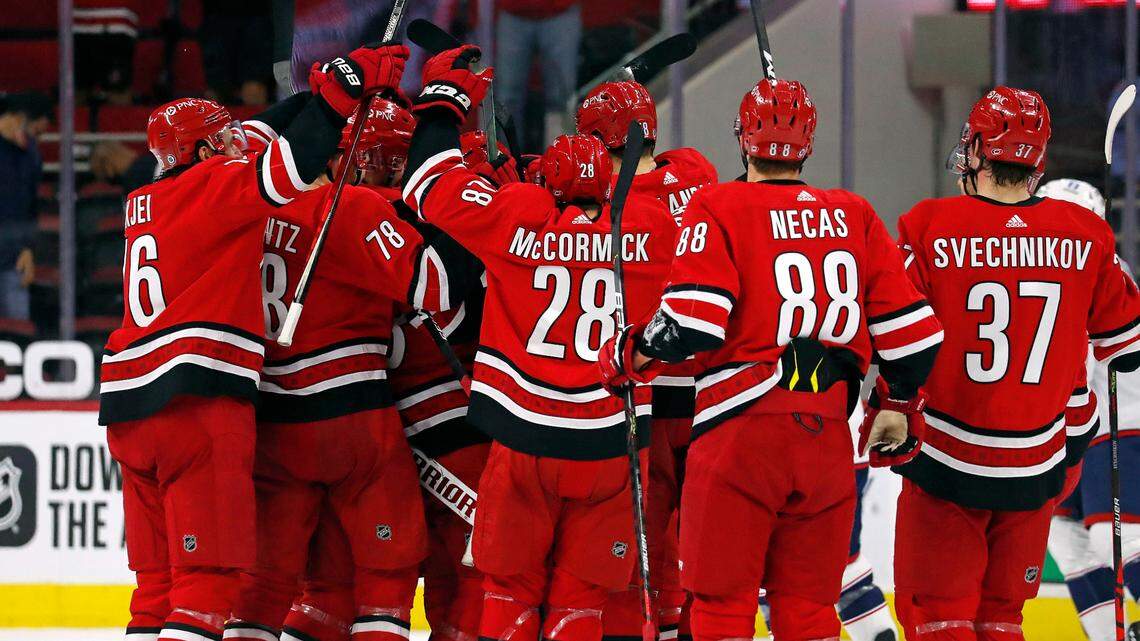 The Carolina Hurricanes surround Dougie Hamilton following his game-winning overtime goal against Columbus Blue Jackets in Raleigh, N.C., Saturday, May 1, 2021. (AP Photo/Karl B DeBlaker)