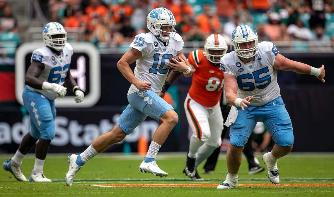 North Carolina quarterback Drake Maye (10) races 33 yards for a first down on fourth down, in the first quarter against Miami on Saturday, October 8, 2022 at Hard Rock Stadium in Miami Gardens, Florida.