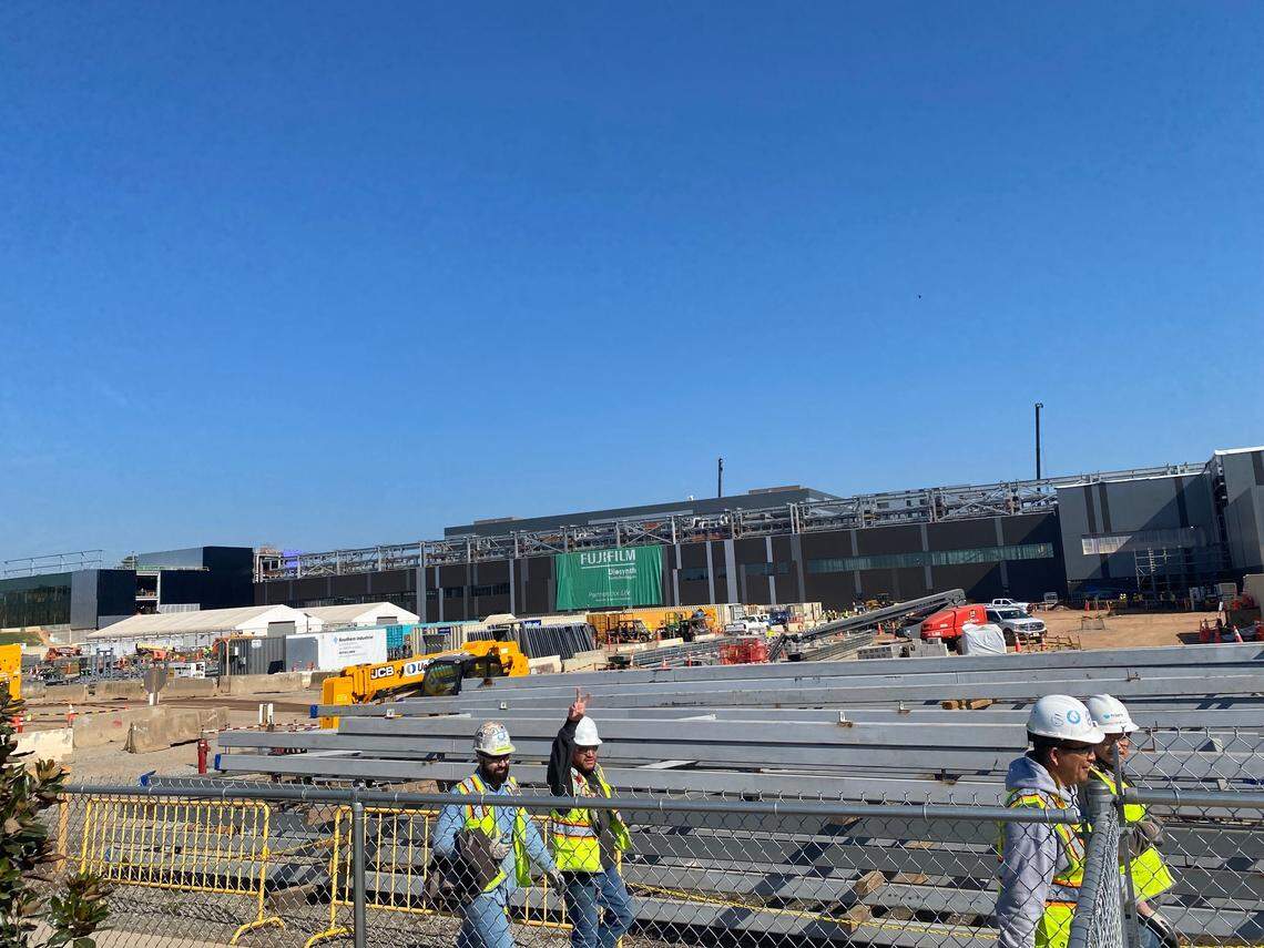 Workers walk by the Fujifilm construction site in Holly Springs, NC.