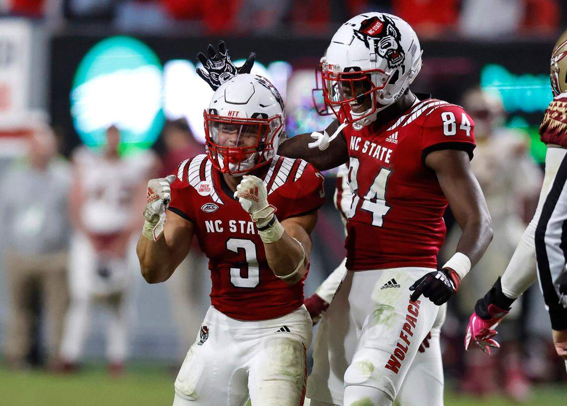 N.C. State’s Jasiah Provillon (84) celebrates with Jordan Houston (3) after Houston ran for a first down to effectively give the Wolfpack the 19-17 victory over Florida State at Carter-Finley Stadium in Raleigh, N.C., Saturday, Oct. 8, 2022.