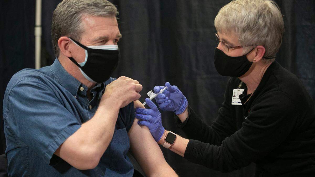 North Carolina Gov. Roy Cooper receives the Pfizer COVID-19 vaccine from Carolyn Knaup, RN, at WakeMed on Wednesday, March 3, 2021 in Raleigh, N.C.