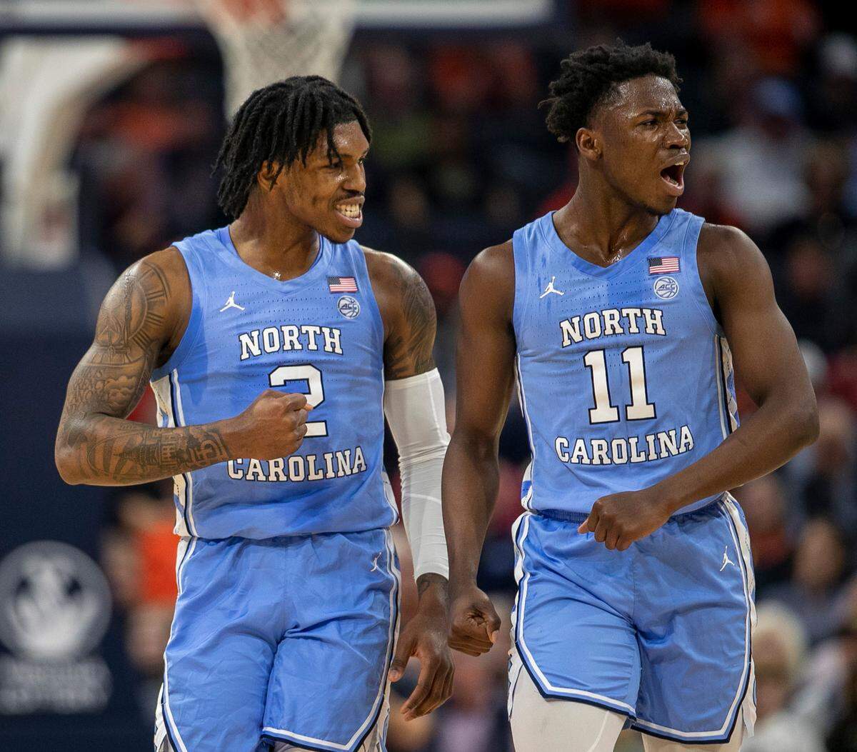 North Carolina’s Caleb Love (2) and D’Marco Dunn (11) reacts after the Tar Heels’ opened a lead over Virginia in the first half on Tuesday, January 10, 2023 at John Paul Jones Arena in Charlottesville, Va.