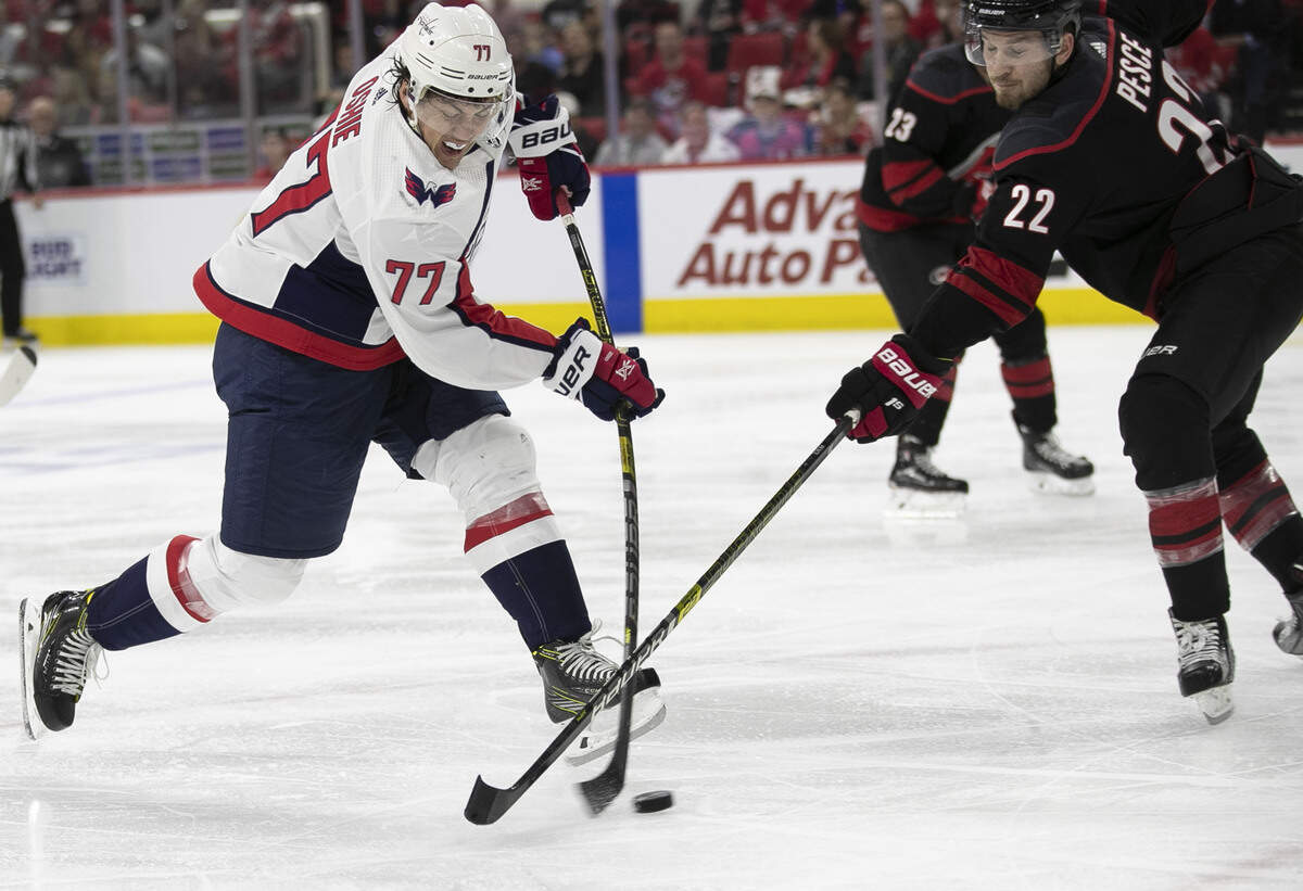 Carolina Hurricanes’ Brett Pesce (22) defends Washington Capitals’ T.J. Oshie (77) during the second period in game four of the first round Stanley Cup series game on Thursday, April 18, 2019 at the PNC Arena in Raleigh, N.C.