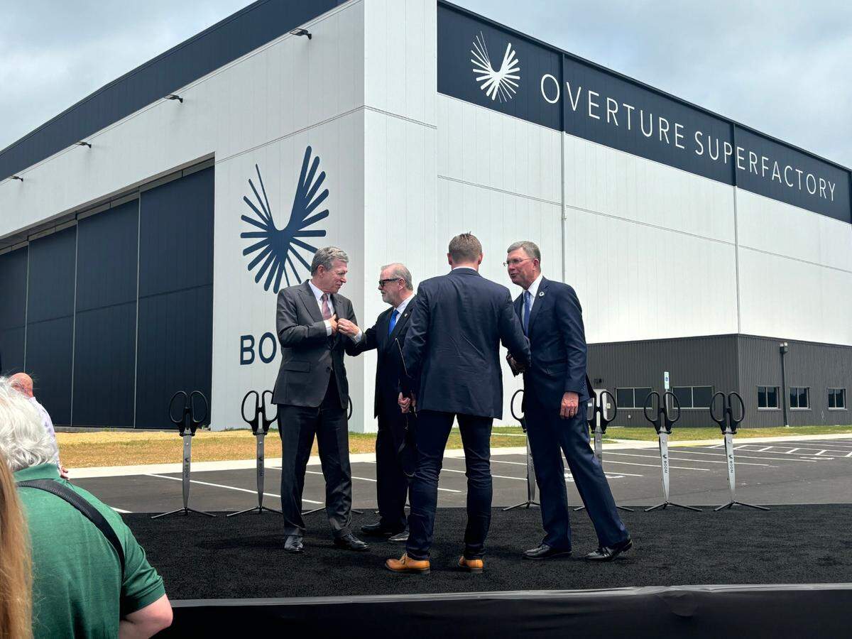 Gov. Roy Cooper (left) greets North Carolina Senate President Phil Berger after they helped cut the ceremonial ribbon on Boom Supersonic’s jet factory at the Piedmont Triad International Airport in Greensboro on June 17, 2024.